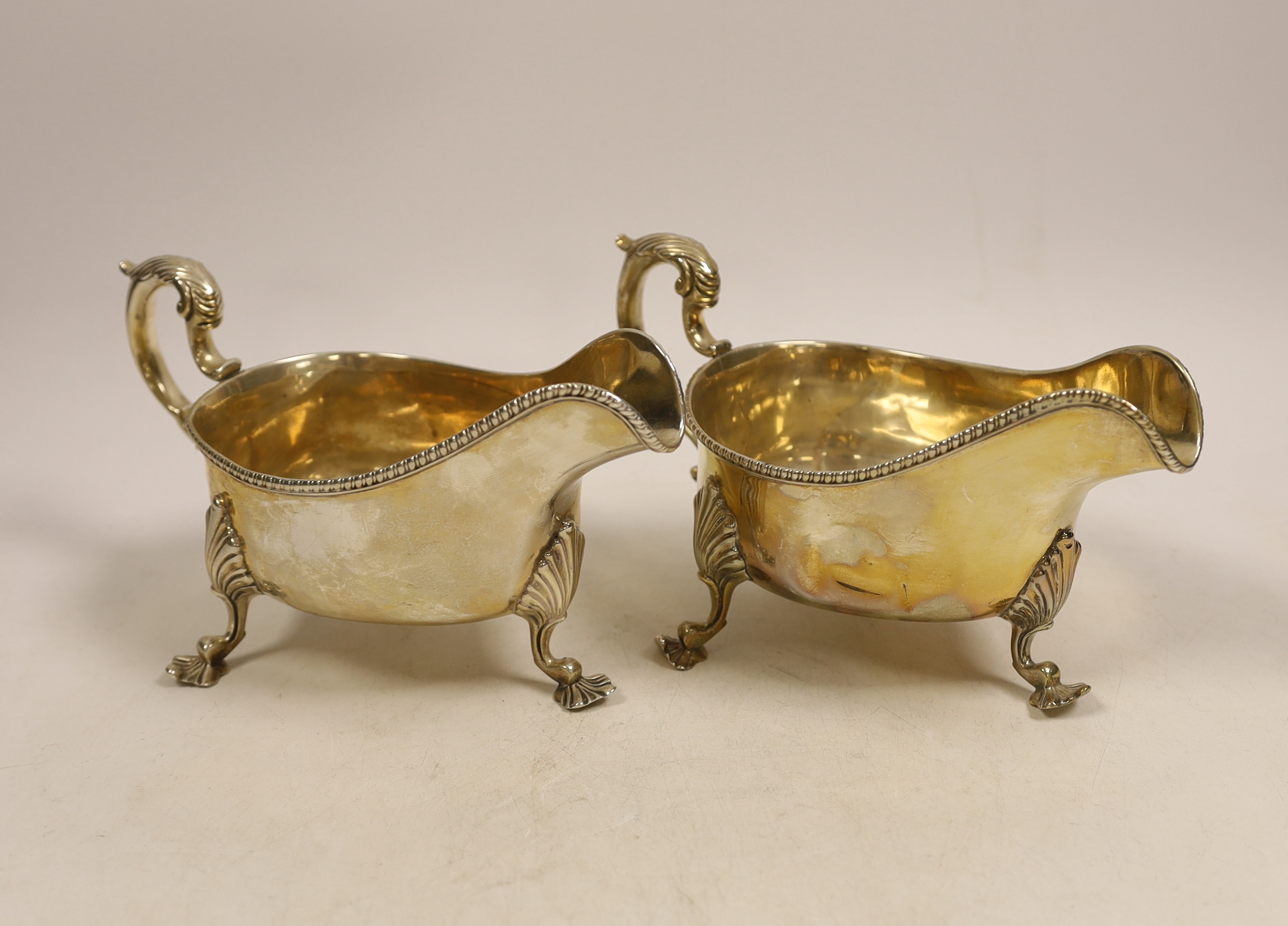 A pair of late Victorian silver sauceboats with gadrooned edge, double scroll handles on three shell and scroll feet, Wakely & Wheeler, London 1895, 21.3oz.